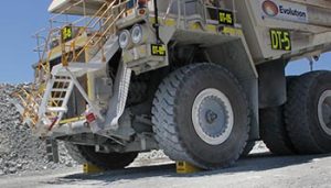 Wheel chock on heavy mining mining truck. Large wheel chock for mining industry